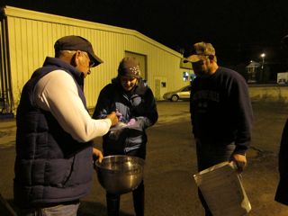 An elver fisherman sells his catch to a dealer as Beth Bisson looks on