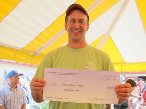 Dana Morse holding check for Darling Marine Center