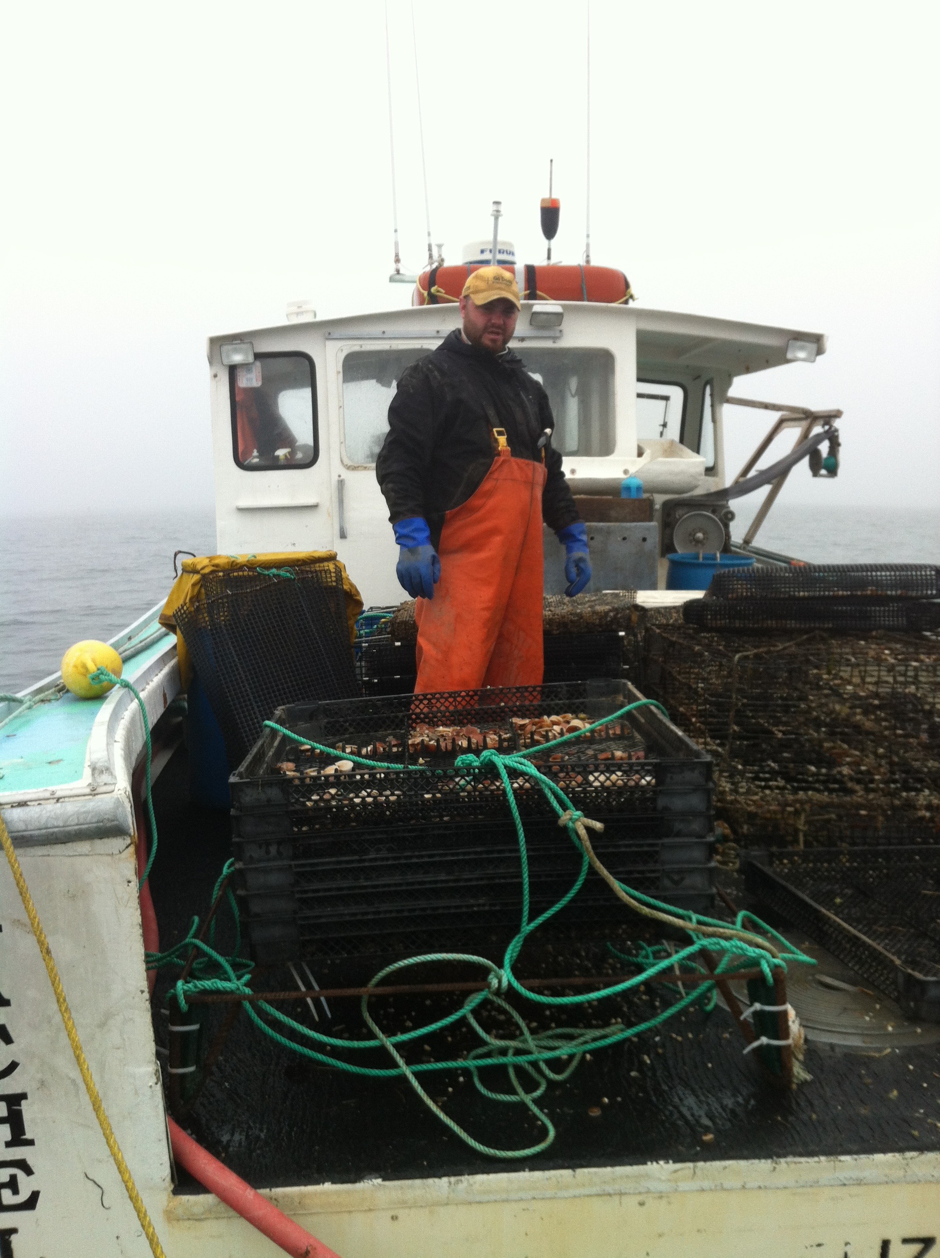 Nate Perry on boat with scallop cages
