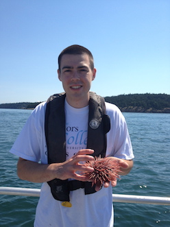 Tyler with an urchin on a boat.