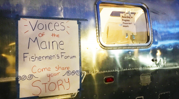 A handwritten sign on the window of an Airstream trailer reading 'Voices of the Maine Fishermen's Forum - Come share your story'