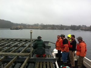 Several peope in life vests standing on a mussel raft