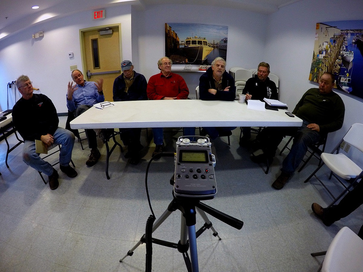 photo of fishermen sitting around audio recording equipment