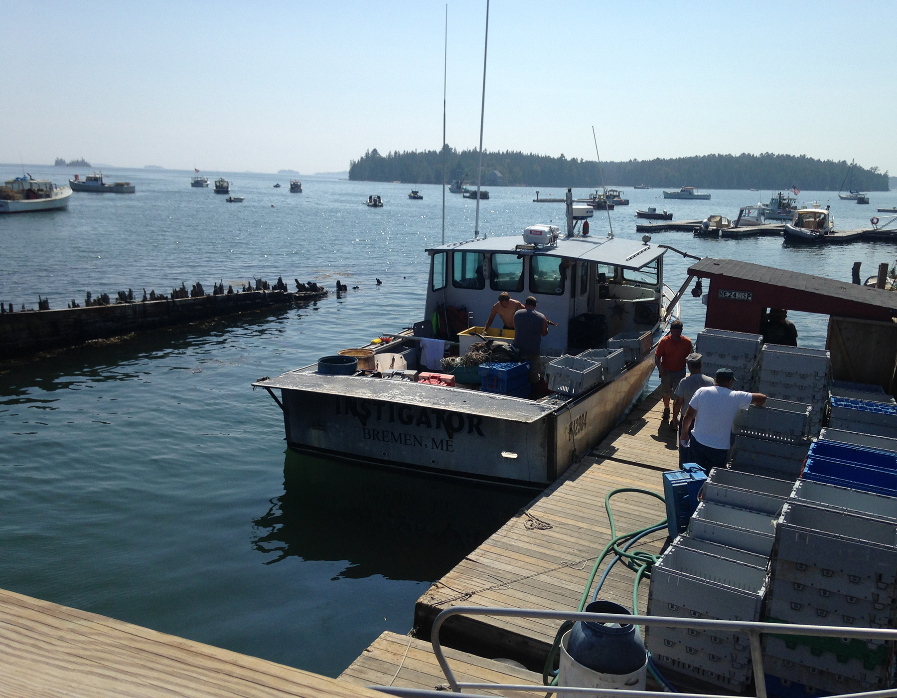 two men aboard a working boat at dock