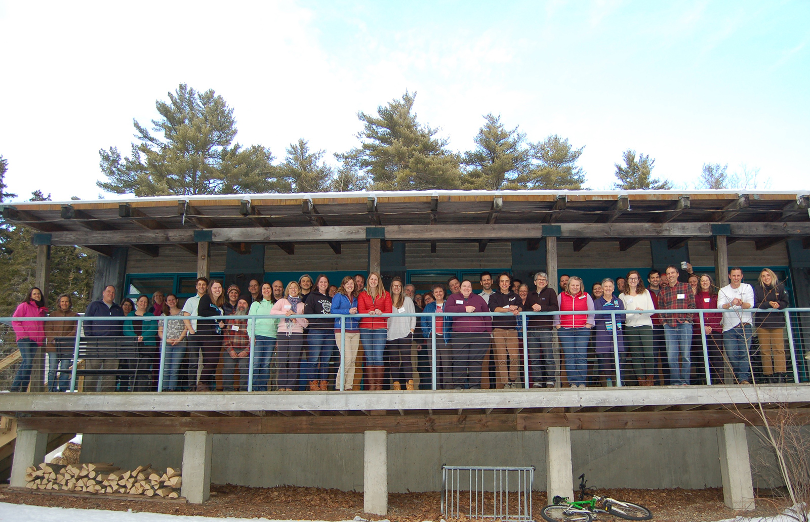 Dozens of conference participants line up for an outside photo