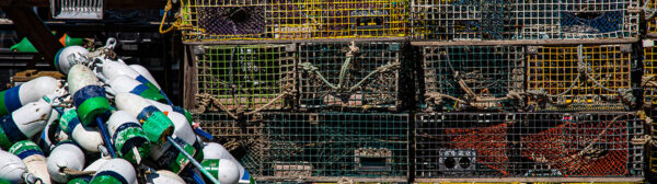 a pile of buoys next to a pile of lobster pots
