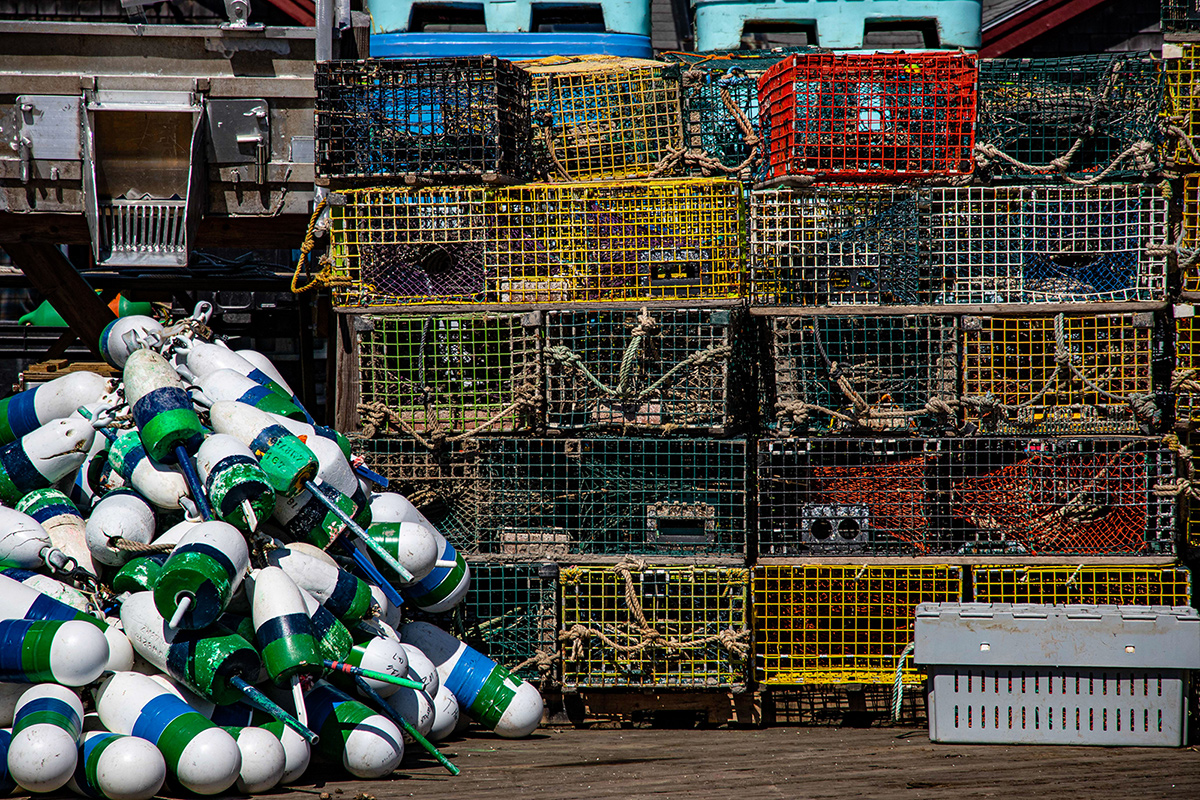 a pile of buoys next to a pile of lobster pots