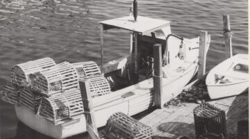 black and white historic photo of a moored lobster boat