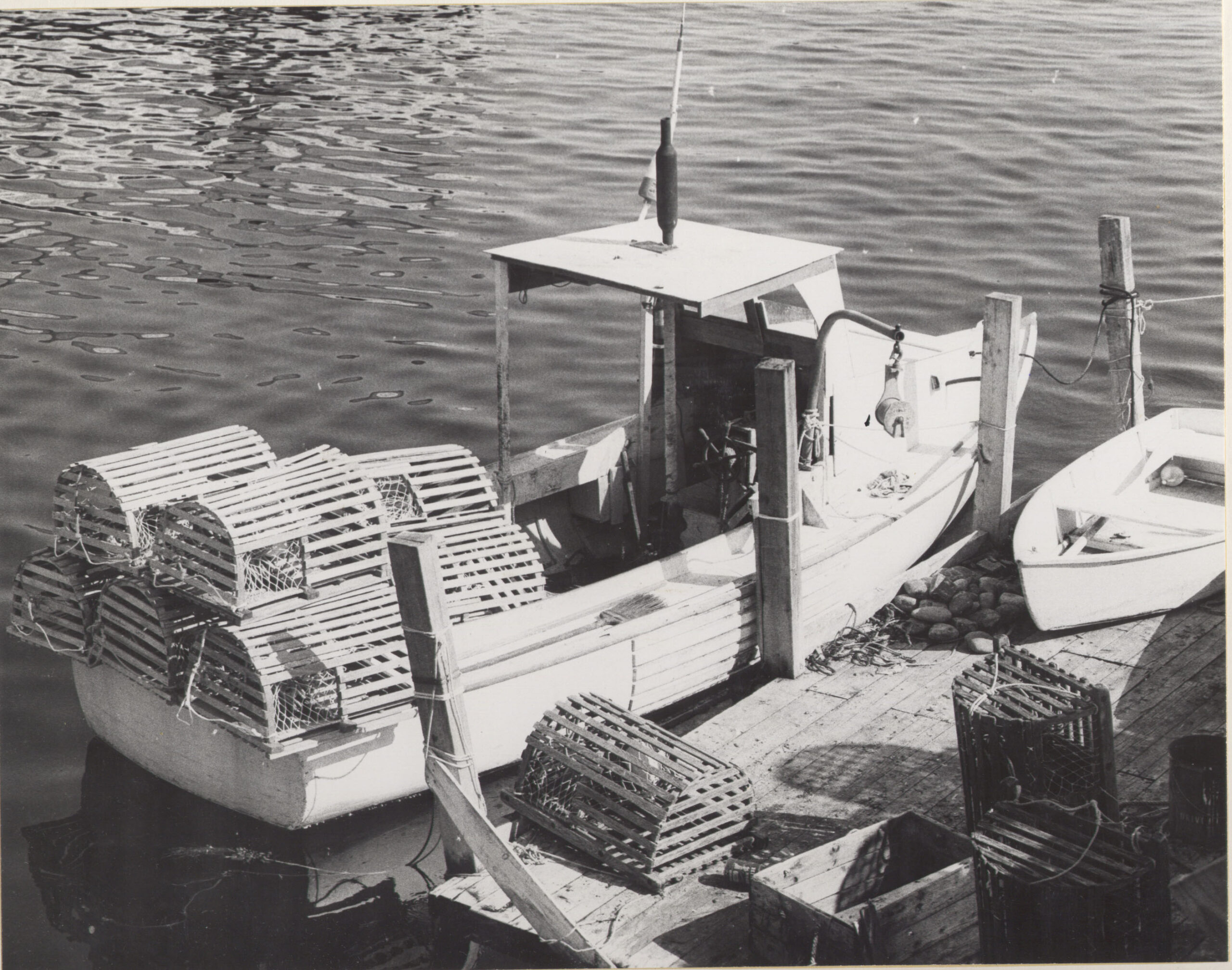 black and white historic photo of a moored lobster boat