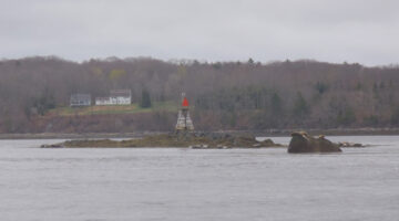 a photo of a marker on land from the vantage point of a boat