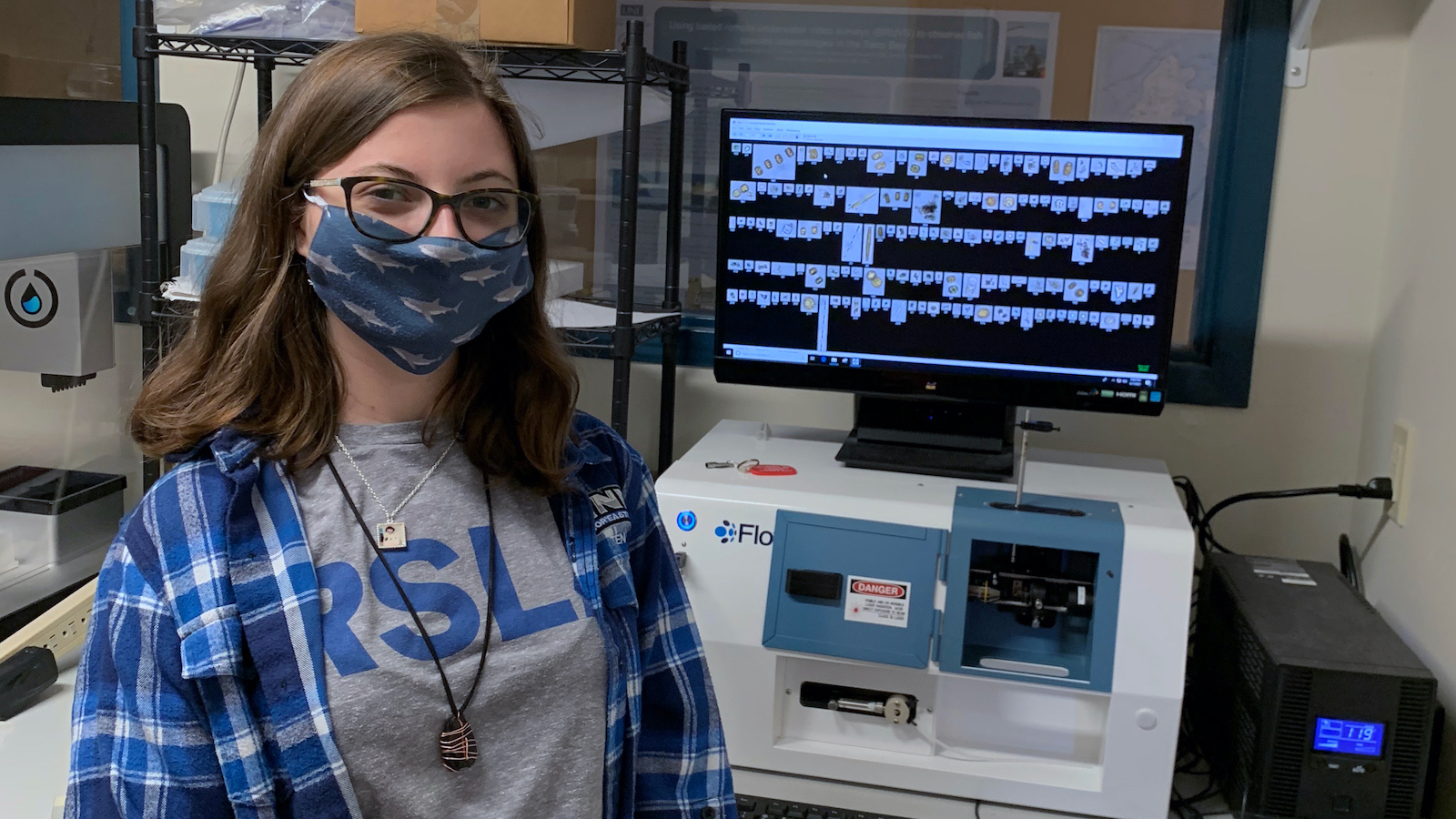 Masked photo of Tessa in front of a computerized display