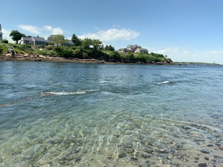 Blue, intertidal waters with a house in the background