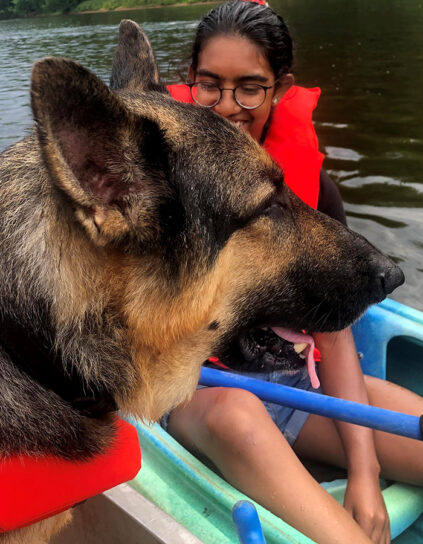 Sneha Suresh in a boat with a dog