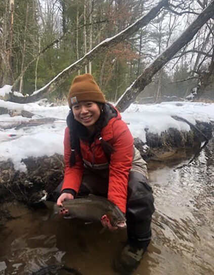 Sara Ang holds a fish in winter waters