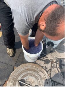 a man bent over a pail with his hands submerged 