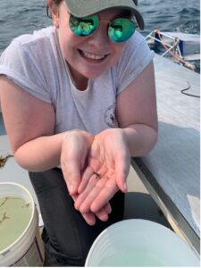 a woman in sunglasses holding small sealife in her hands