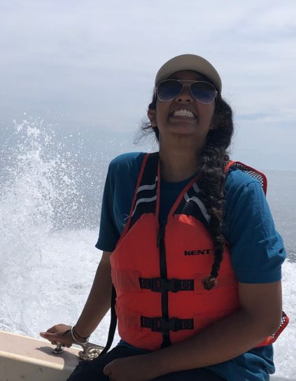 Shreya Vinodh smiling on a boat with water in the background