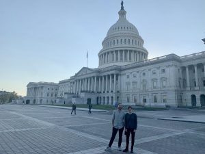 Two people (Lauri Leach and her mentor) pose in front of the Capitol building.