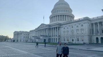 Two people (Lauri Leach and her mentor) pose in front of the Capitol building.