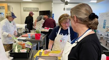 Food service workers preparing Maine seafood in a kitchen.