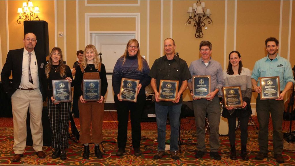 Eight people stand with awards at the 2023 Maine Fishermen's Forum