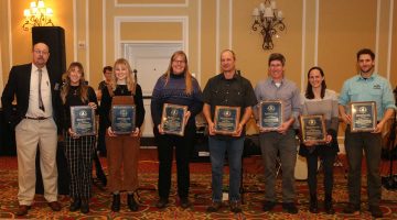 Eight people stand with awards at the 2023 Maine Fishermen's Forum