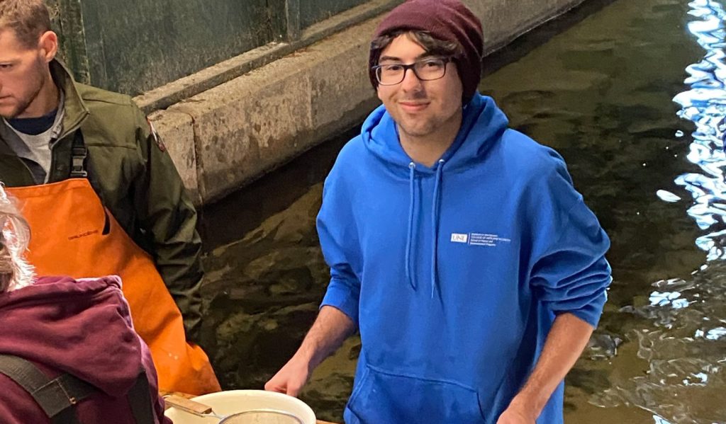 Brian Will smiles for the camera with water in the background