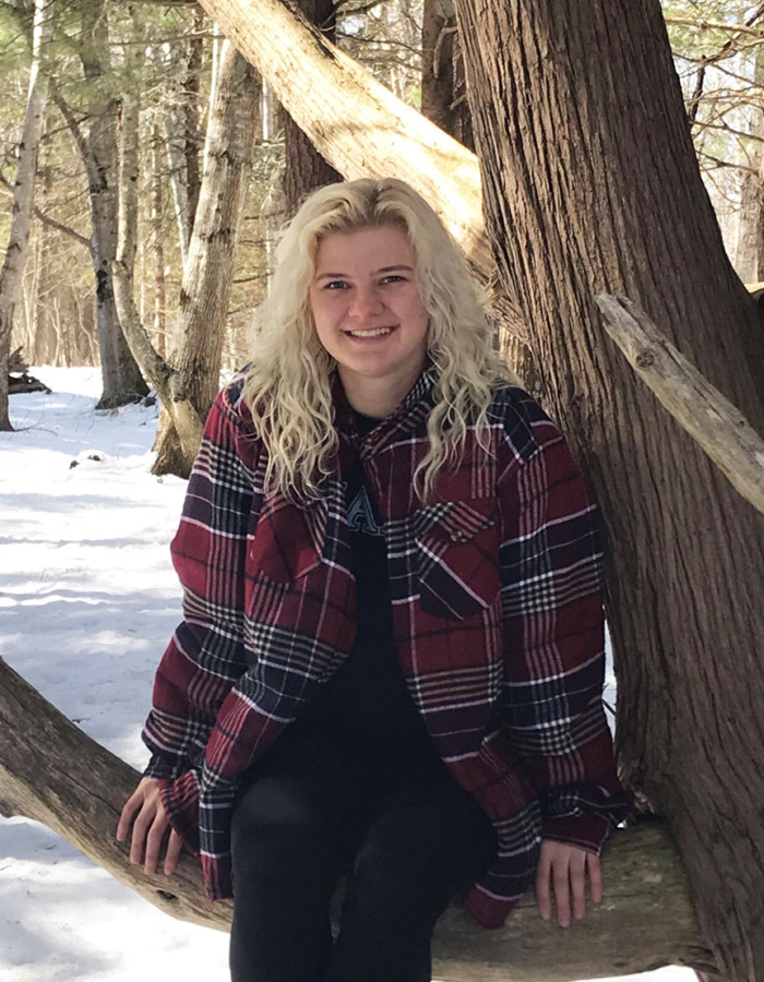 Emily Hartmann standing in the snowy woods