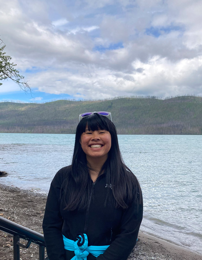 Tess Hureau under a cloudy sky by the water's edge