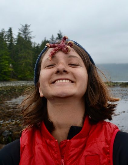 Linnea Goh standing at the shore with a starfish on her forehead