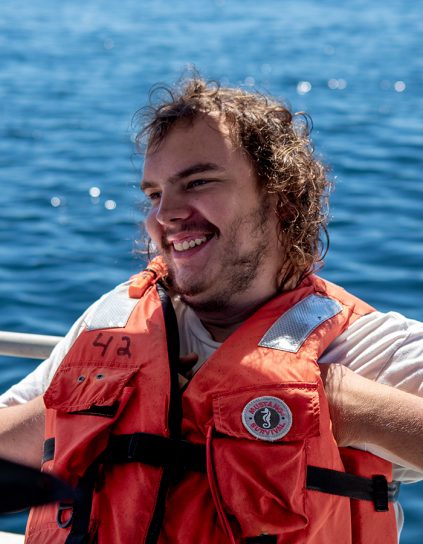 Terrance Meinardus wearing an orange lifejacket with blue water behind