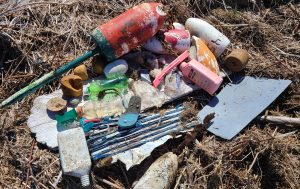 A gathered pile of marine debris, large pieces of plastic including buoys and other trash