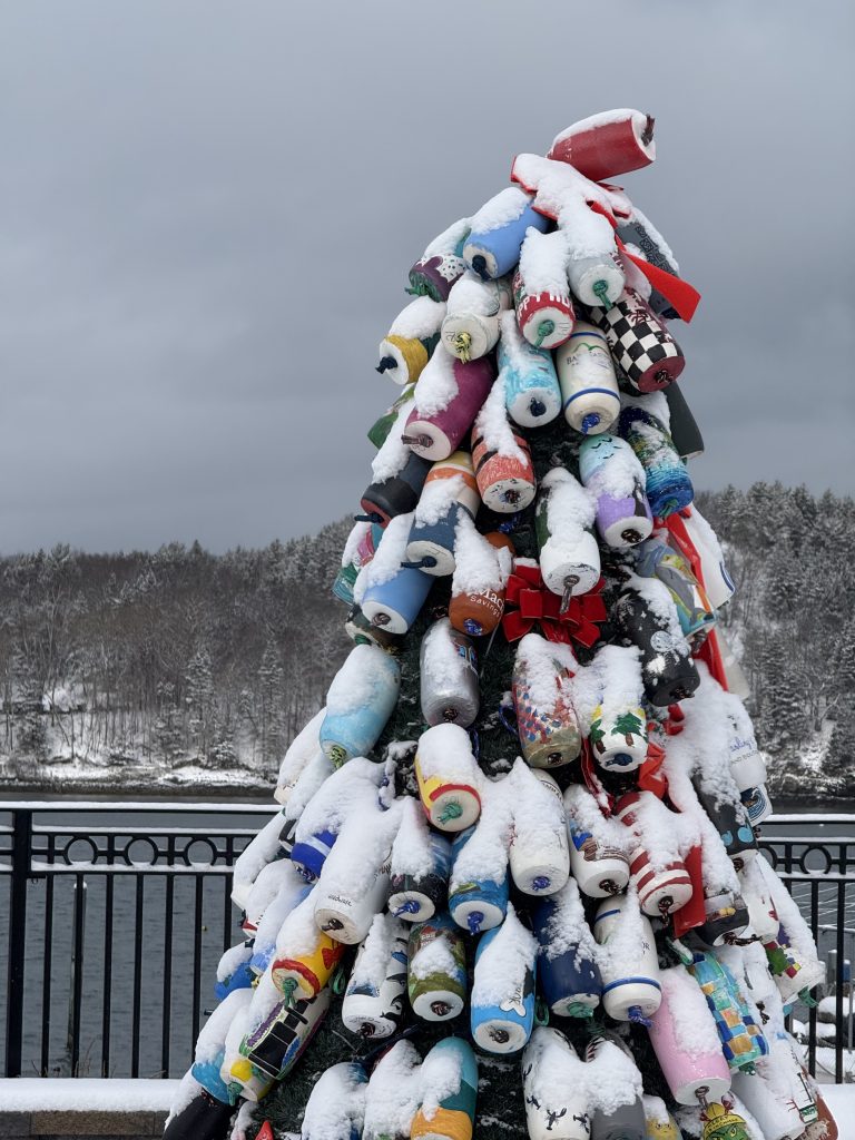 Christmas tree in Bar Harbor decorated with buoys covered in snow.