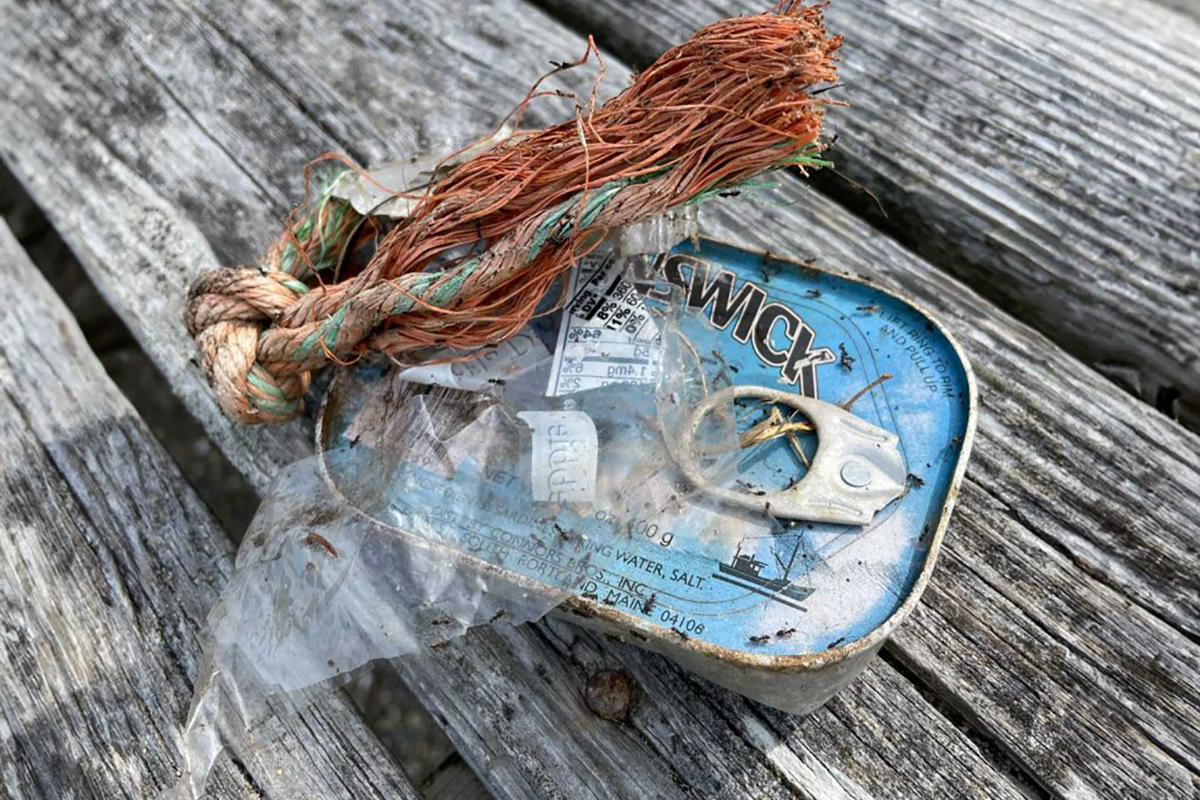 a sardine can, a bit of rope, and some cellophane plastic on a weathered dock